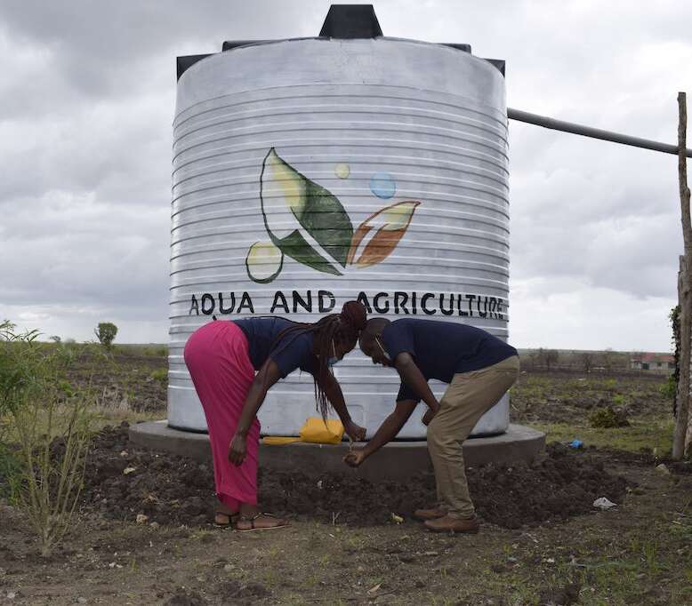 Community member drawing clean water from an Aqua tank